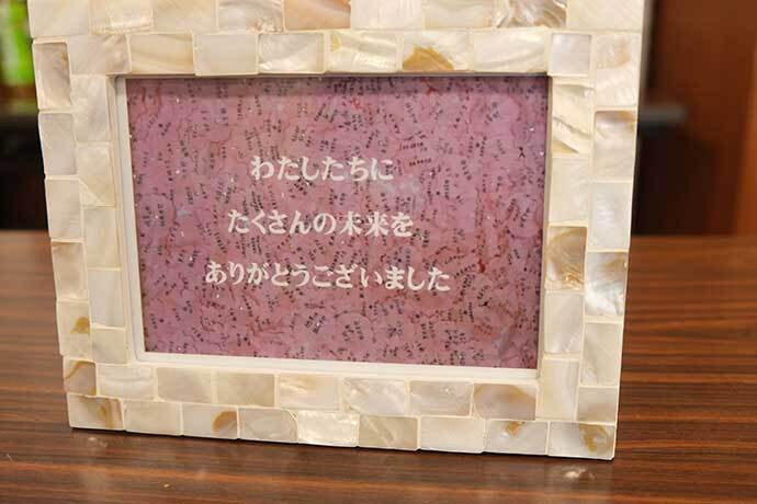 萩原校長が昭和高校退任時に贈られた記念プレート。生徒が合格した大学名を書いた桜の形の紙が並んでいる