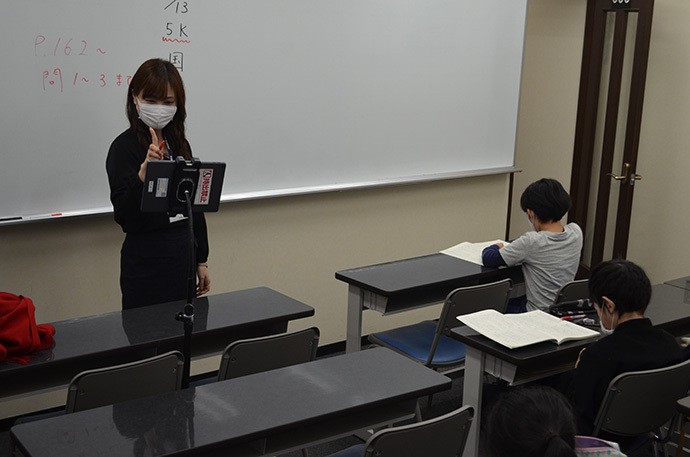 講師は対面授業をしながら、オンラインで受けている生徒にも声をかける=早稲田アカデミー池袋校