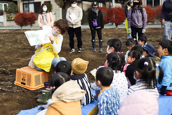 畑で子どもたちに絵本を読む圓山さん。絵本タイムを楽しみにしている子どもも多いそう